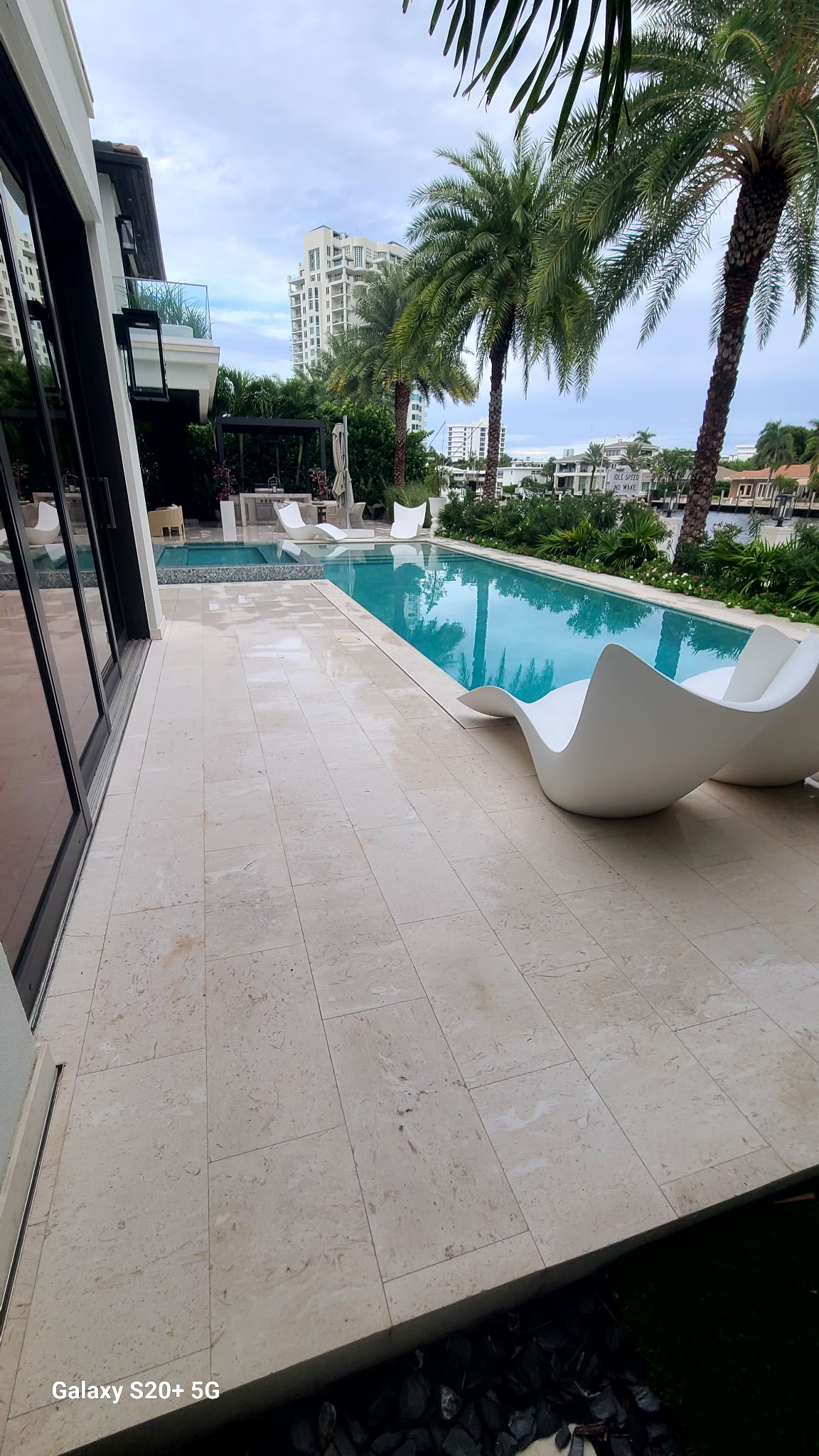 Waterfront travertine pool deck cleaned by JB Powerwash